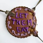 Chocolate cake with let them eat cake message, top view — Stock Photo