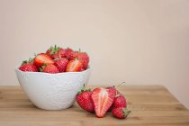 Bowl of fresh strawberries on wooden table — Stock Photo