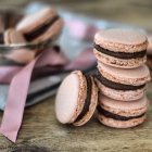 Montón de macarrones rosados con relleno de chocolate, primer plano - foto de stock