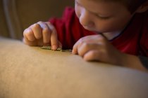 Close-up de focado pequeno menino brincando com lagarta — Fotografia de Stock