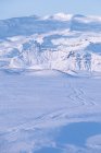 Vista panorámica de las pistas de neumáticos de vehículos en la nieve, Islandia - foto de stock