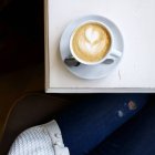 Cup of cappuccino coffee on a table, top view — Stock Photo