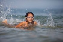 Целенаправленная девушка плавает в море в очках — стоковое фото