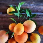Heap of oranges and lemons on wooden table — Stock Photo
