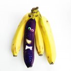 Um bando de bananas com um carácter de banana roxa — Fotografia de Stock