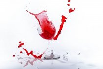 Vaso de líquido rojo en copa de vino rota - foto de stock