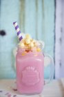 Glass jar with strawberry milkshake and marshmallows — Stock Photo