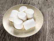 Pila di marshmallow su un piatto su sfondo di legno — Foto stock