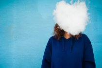 Giovane donna con testa in nuvola di fumo di vapore su sfondo blu — Foto stock
