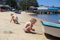 Due sorelle carine che giocano con la sabbia in spiaggia — Foto stock