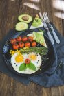 Смажені яйця, вишневі помідори, авокадо, спаржа та тости сніданок — стокове фото