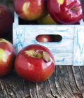 Красные яблоки в деревянном ящике, крупный план — стоковое фото