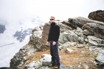 Uomo con gli occhiali da sole in piedi su una montagna, Zermatt, Svizzera — Foto stock