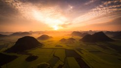 Salida del sol sobre campos de colza oleaginosa, Luoping Yunnan, China - foto de stock