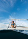 Schöne junge Frau im blauen Badeanzug, die aus dem Meer auf ein Boot steigt, bali, Indonesien — Stockfoto