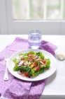 Plate of fresh green salad over kitchen table — Stock Photo