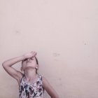 Усталая девушка с рукой на голове на бежевом фоне — стоковое фото