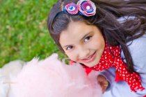Портрет усміхненої дівчини, що тримає бавовняні цукерки — стокове фото