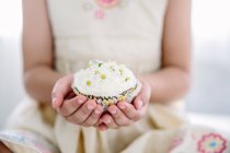 Cropped image of Girl holding cupcake — Stock Photo