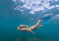 Rubia mujer nadando bajo el agua con aletas - foto de stock