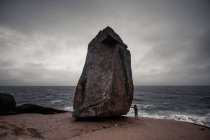 Hombre de pie en Pedra do frade rock, Laguna beach, Santa Catarina, Brasil - foto de stock