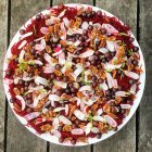 Salat mit Roter Bete, Rettich, Pekannüssen und Blaubeeren auf Teller auf Holz — Stockfoto