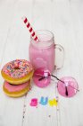 Rosa Donuts, rosa Sonnenbrille und Erdbeer-Milchshake — Stockfoto