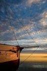 Bow of wooden sailing boat at sunset — Stock Photo