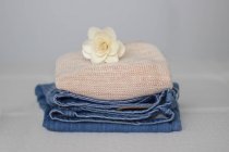 Vista close-up de pilha de roupas com uma flor no topo — Fotografia de Stock