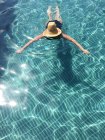 Woman wearing straw hat in swimming pool — Stock Photo