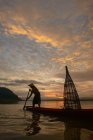 Силуэт человека, рыбачащего в озере, Таиланд — стоковое фото