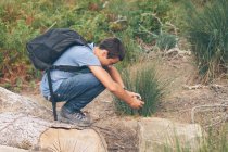 Rapaz agachado para tirar fotos em bosques — Fotografia de Stock