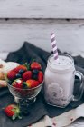 Glass jar of summer fruits smoothie with strawberries and blueberries — Stock Photo