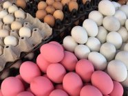 Rosafarbene, weiße und braune Eier auf Bauernmarkt — Stockfoto