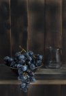 Mazzo di uva rossa in ciotola sul tavolo — Foto stock
