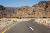 Живописный вид на пустую дорогу через горы, Оман — стоковое фото