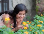 Jovem mulher colhendo flores no jardim — Fotografia de Stock