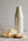 Bottle of milk and loaf of wholemeal bread — Stock Photo