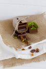 Chocolate, nuts and dried fruits on linen cloth — Stock Photo