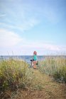 Блондинка дівчина гуляє на пляжі з собакою — стокове фото