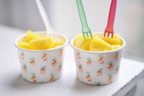 Two paper cups filled with pineapple chunks — Stock Photo
