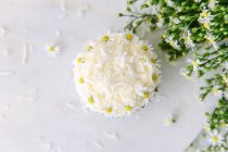 Elevated view of a cupcake decorated with daisies — Stock Photo