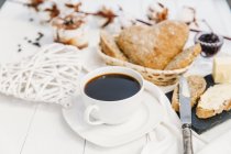 Nahaufnahme von Kaffee mit Brötchen, Butter und Marmelade — Stockfoto