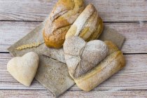 Pani a forma di cuore di pane su sfondo di legno, vista dall'alto — Foto stock