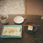 Вкусный экзотический корейский десерт за деревянным столом — стоковое фото