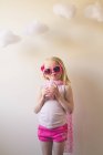 Menina vestindo roupas rosa e óculos de sol bebendo um milkshake rosa — Fotografia de Stock