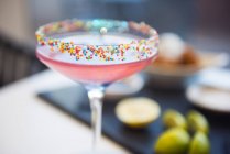 Красочный коктейль, украшенный сотнями и тысячами на ободке — стоковое фото