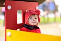 Mädchen mit rotem Hut sitzt in einem Spielhaus — Stockfoto