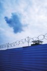 Облака над оградой из колючей проволоки в тюрьме — стоковое фото
