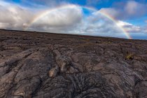 Scenic view of rainbow over Lava Fields, Hawai 'I Volcanoes National Park, Hawaii, America, USA — стоковое фото